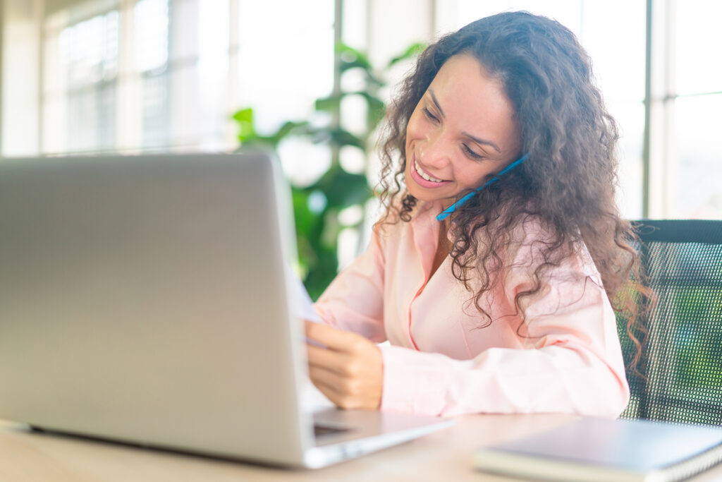 Latin woman working with phone on working space